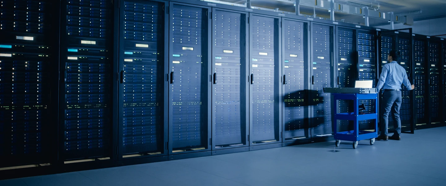 Man standing in front of large bank of data center equipment